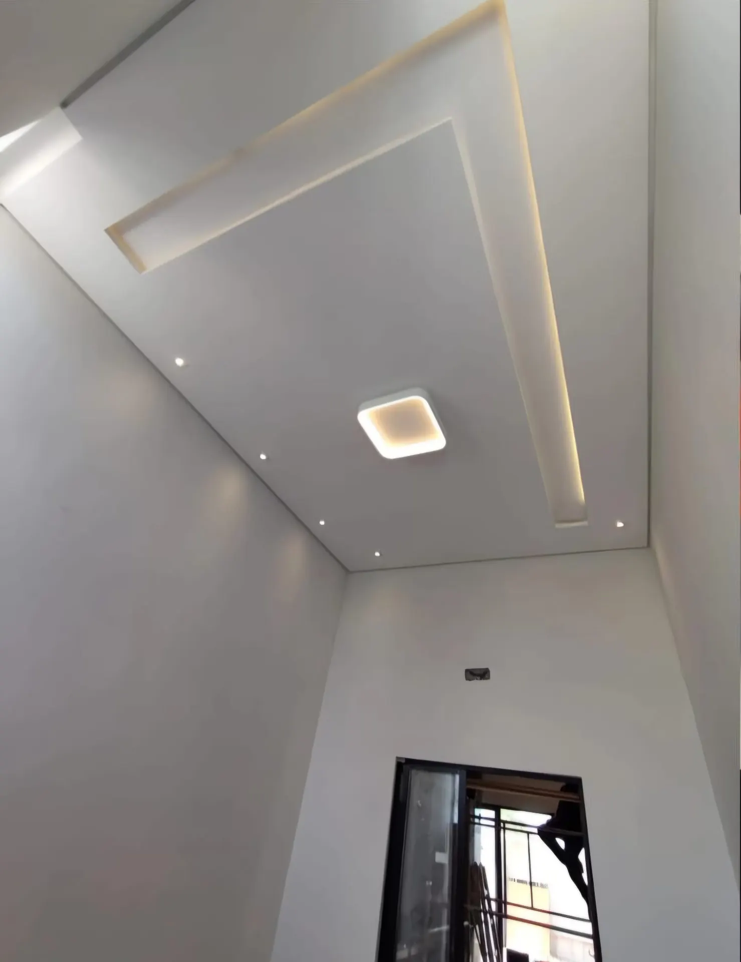 Teto decorativo de gesso com recortes geométricos e iluminação indireta